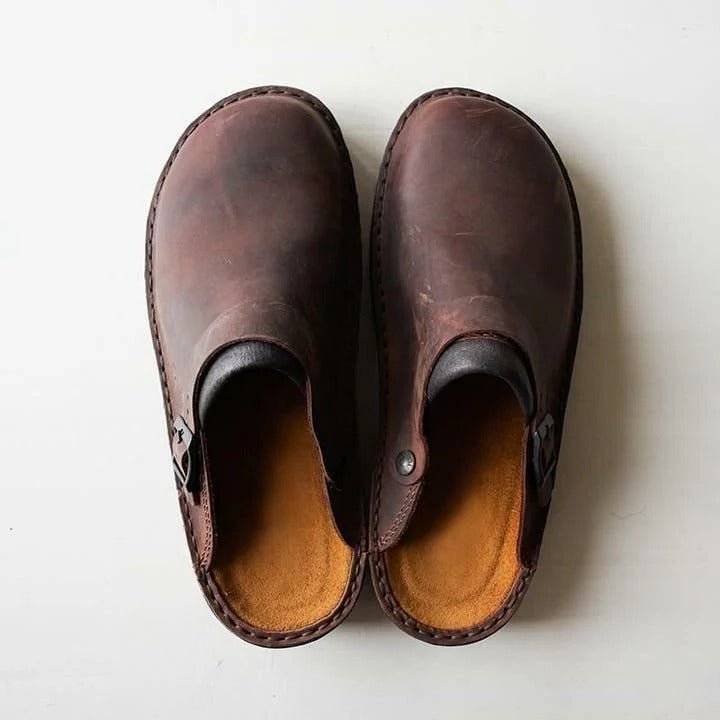Men's black slip-on mules with a heel strap for secure comfort. Casual everyday footwear.