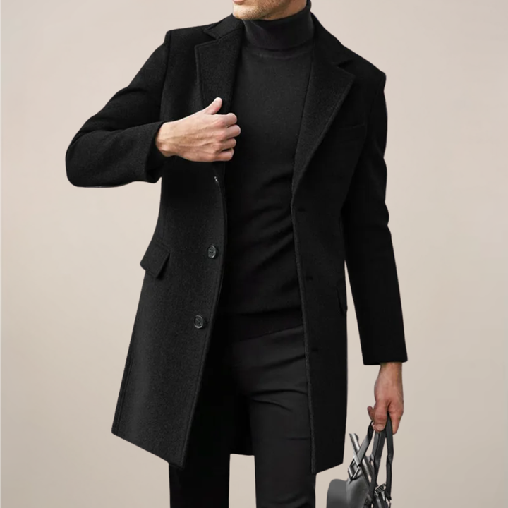 Men's black tailored long overcoat, perfect for elegant winter formal wear. Single-breasted trench coat style.