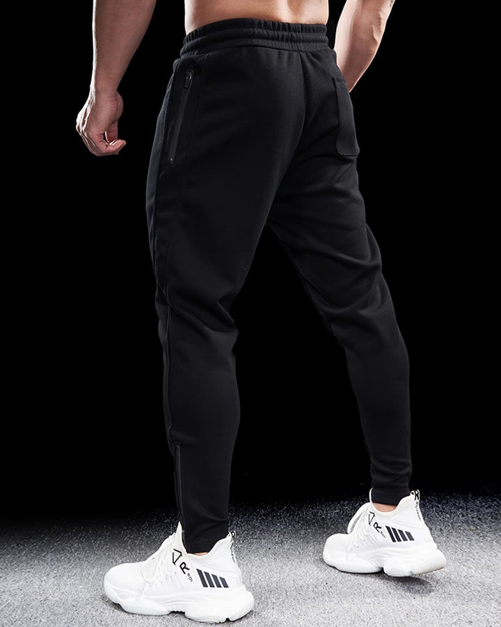 Close-up of the zippered hem on men's tapered track joggers, showcasing quality and adjustable fit.