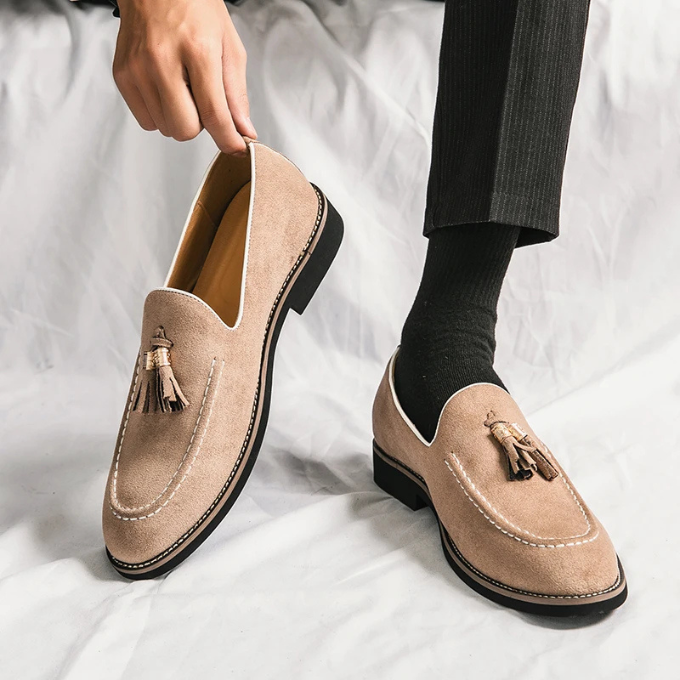 Close-up of a men's burgundy velvet loafer with decorative tassels