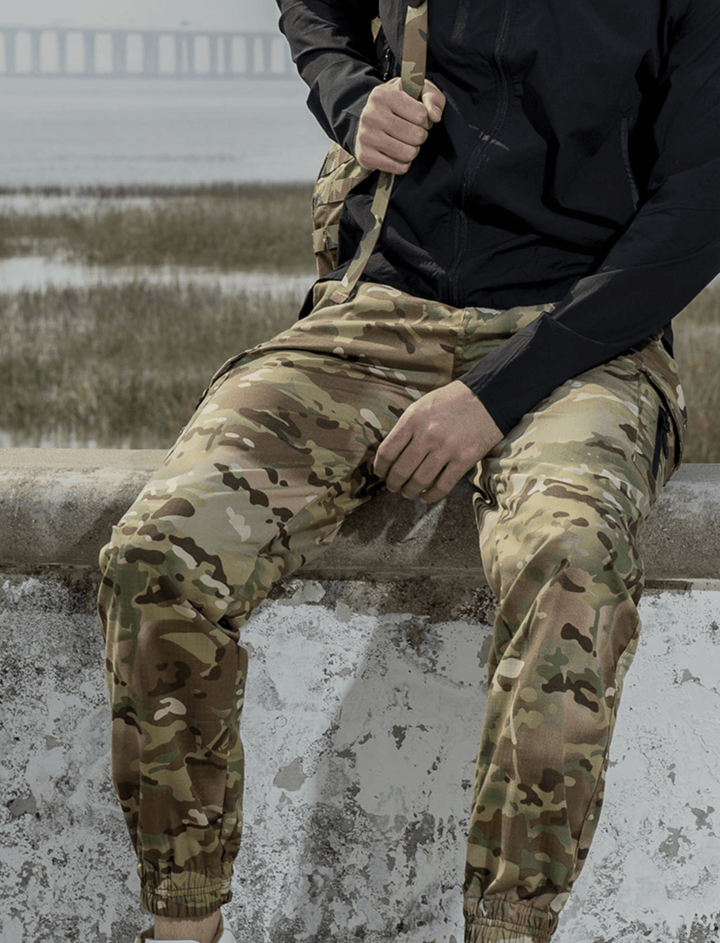 Men's techwear jogger pants in a dynamic pose, highlighting their athletic and flexible nature