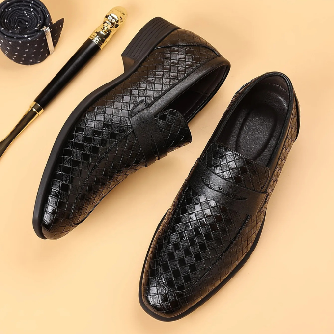 Stylish men's brown woven leather loafers displayed on a natural wood surface.