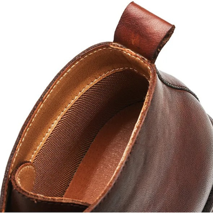 A man wearing classic leather dress boots with a suit, formal fashion.