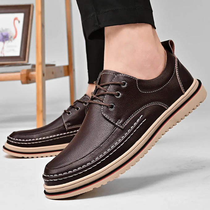 Close-up of the smooth leather texture on classic black men's moc-toe Derby shoes.