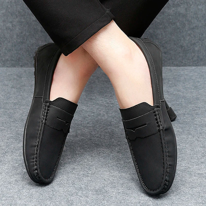 Close-up of the penny slot on men's classic leather loafers, a signature detail.