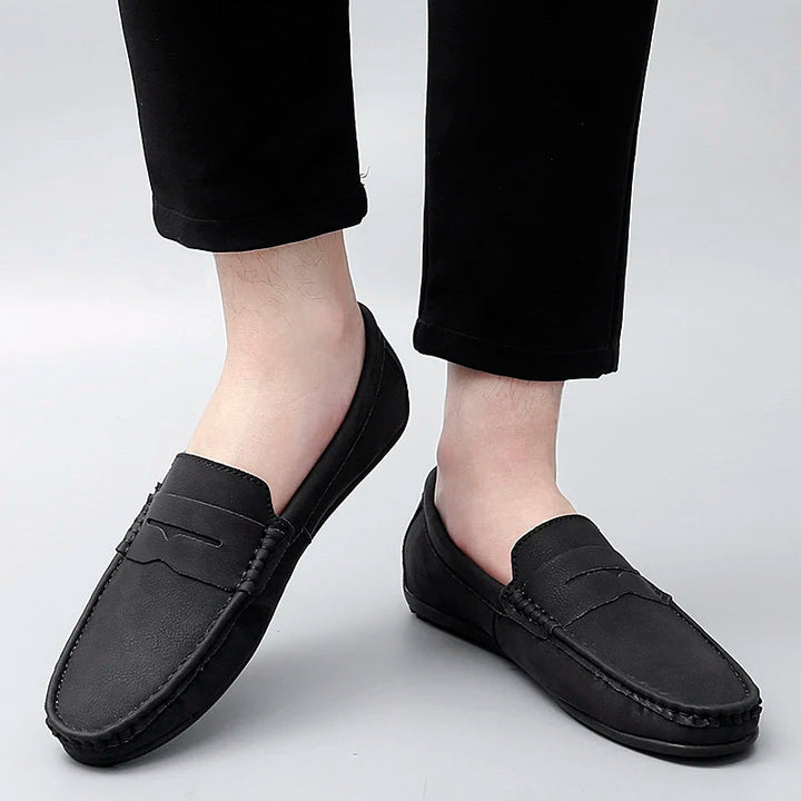 Men's classic black leather penny loafers, offering a smart and adaptable look.