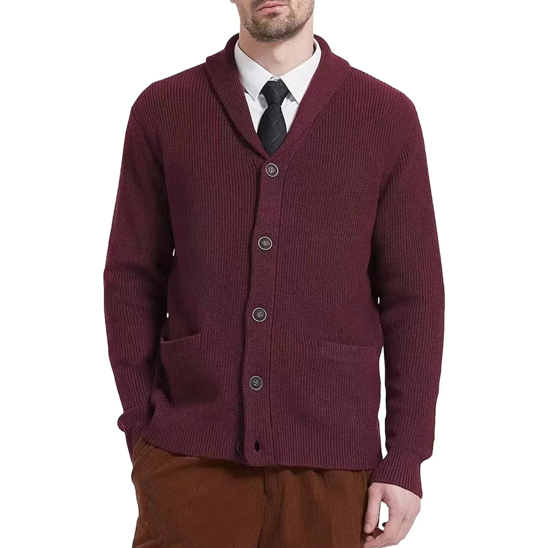 Stylish men's winter wear: a button-front cable knit cardigan draped over a chair, ready for layering.