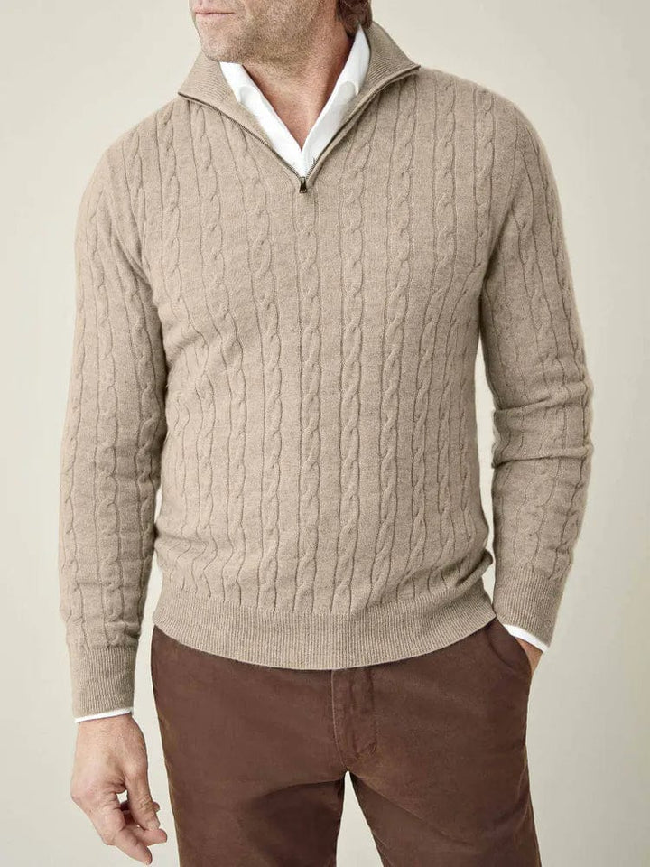 Close-up detail of men's cable knit half-zip jumper. Features classic texture, stand collar, and rib trim.