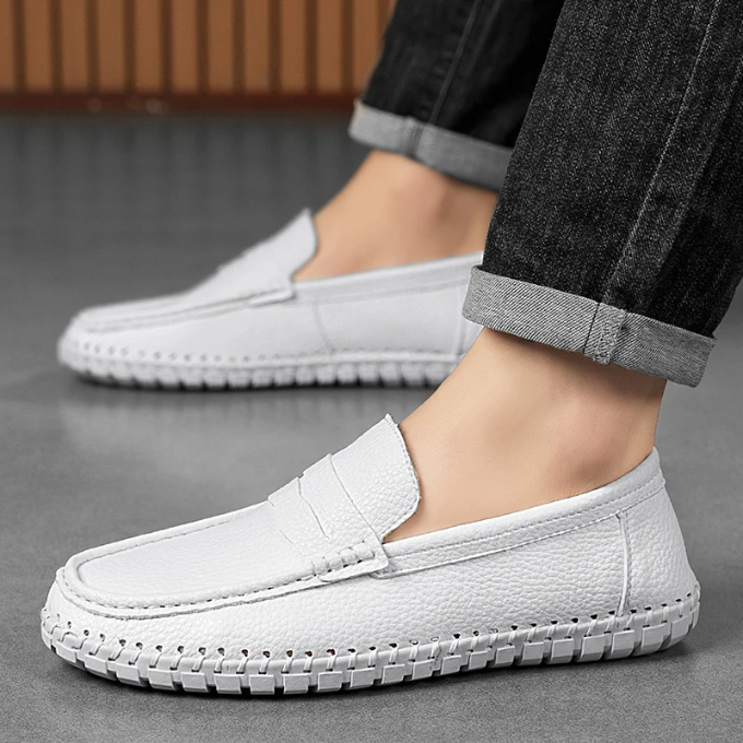 Stylish men's full-grain leather loafers on a wooden background, casual dress shoes