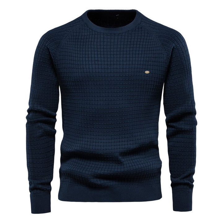 Close-up of the textured knit on a men's classic crewneck sweater, highlighting its quality.