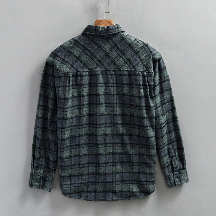 Stylish man wearing a long-sleeve men's flannel shirt in a blue and green plaid pattern, perfect for layering