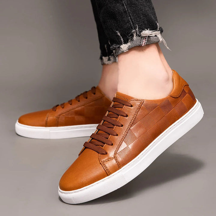 Detailed close-up of men's navy blue leather low-top sneaker, highlighting genuine leather texture