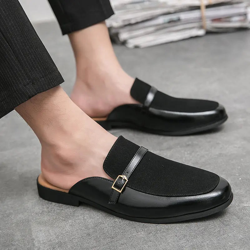 Dressy yet casual men's black leather mule slippers with an elegant buckle, offering easy slip-on convenience.
