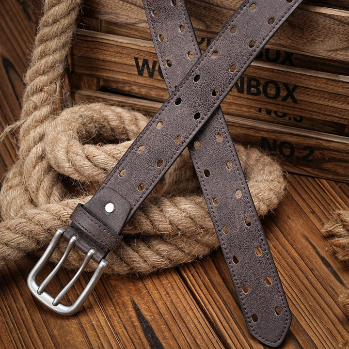 Texture shot of men's distressed leather belt, showcasing the rich brown color and detailed perforated pattern.