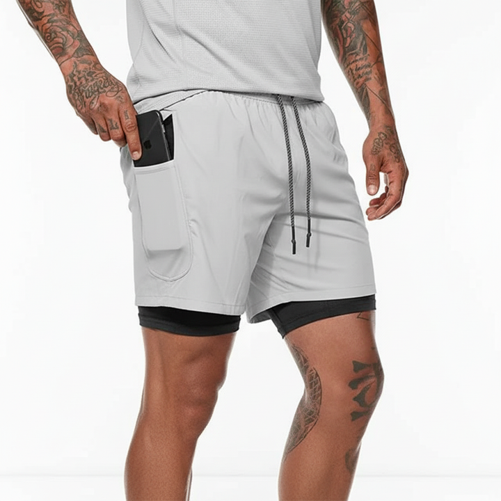 Man standing, wearing RunVibeX men's athletic shorts, highlighting modern style and comfortable fit.