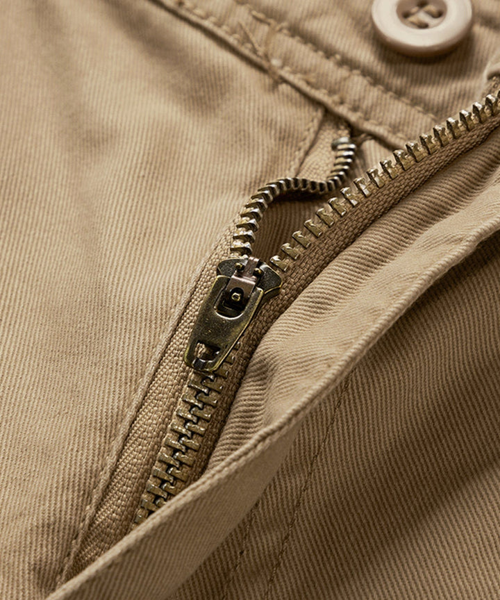 Pair of men's green cotton cargo shorts on a hanger, ready for sale.