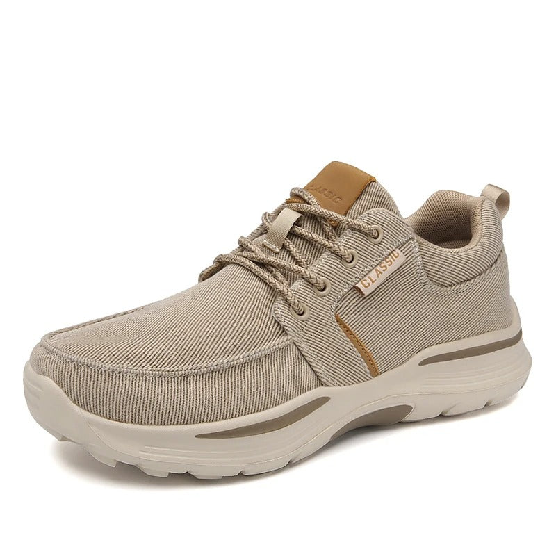 Men's gray canvas comfort sneakers on a wooden surface, highlighting their casual and versatile appeal.