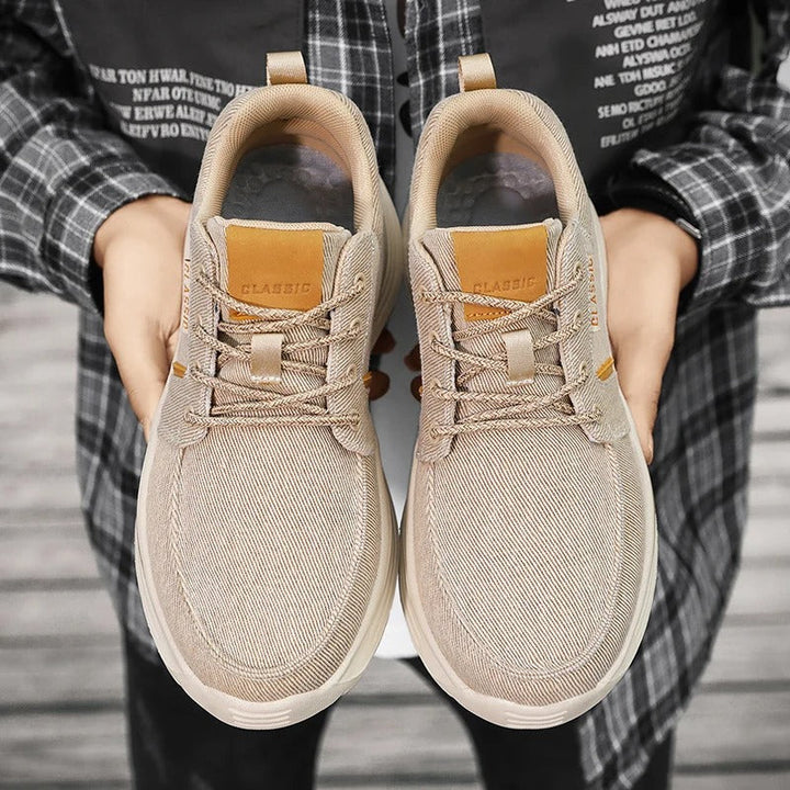Side view of men's blue canvas comfort sneakers, featuring a moc toe design and lightweight sole.