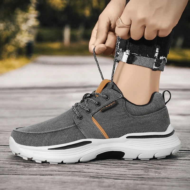 Detail of the moc toe stitching on men's blue canvas comfort sneakers, a classic casual design.
