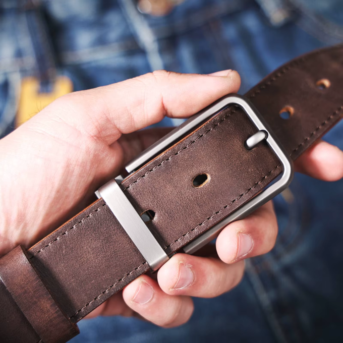 Stack of men's full-grain leather belts: brown, black, and dark brown, durable options