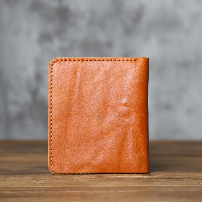 Men's accessory: full-grain leather bi-fold wallet in a classic dark brown, developing a unique patina.
