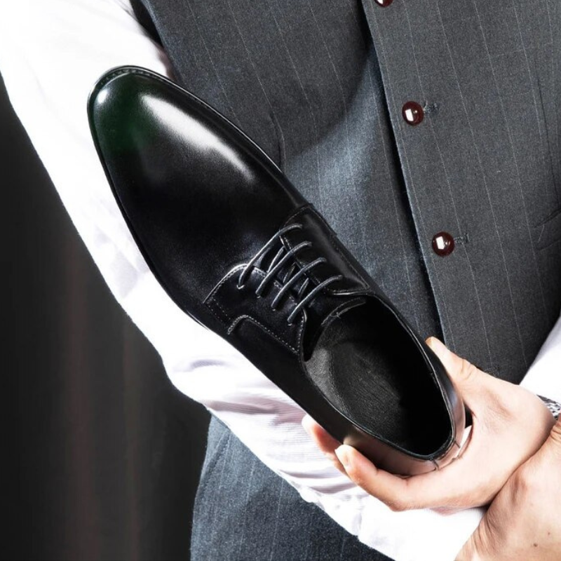 Pair of black genuine leather dress shoes for men, versatile and comfortable formal oxfords.