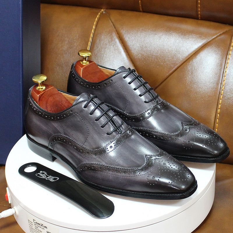 Classic men's handcrafted Oxford dress shoes with intricate wingtip brogue detailing, ideal for formal events.