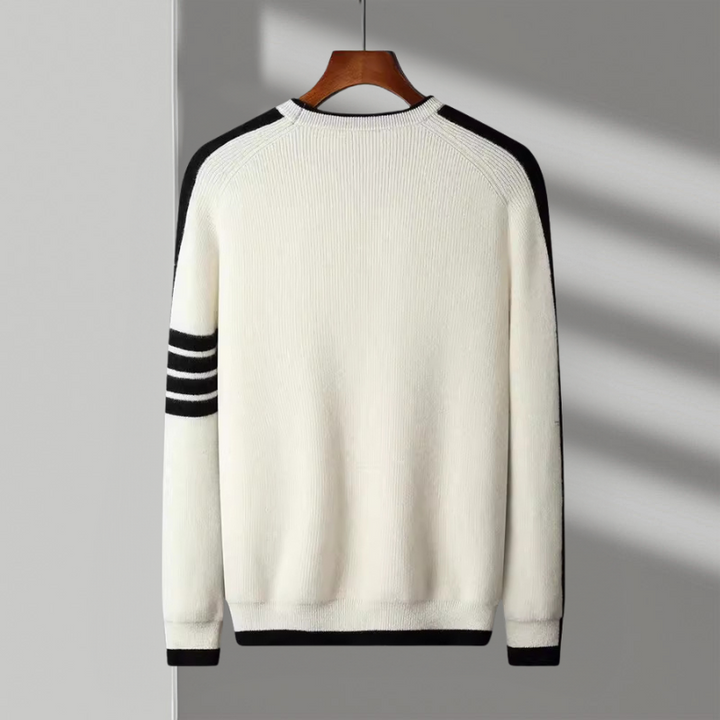 Close-up of the soft knit fabric and contrasting stripe detail on a men's crewneck sweater.