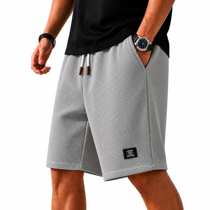 Casual men's lightweight waffle shorts featuring an elastic drawstring waist for summer comfort.