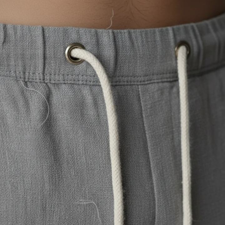 Model wearing men's casual linen trousers, ideal for beachwear & summer comfort. Loose fit.