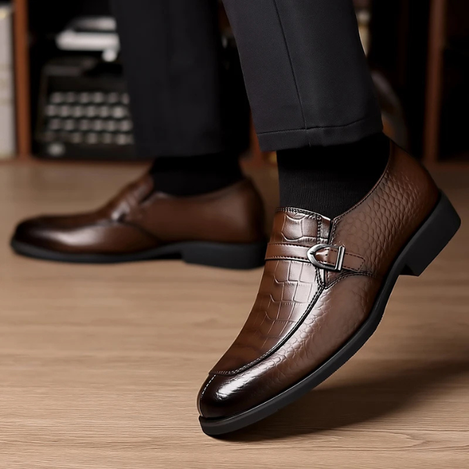 A man wearing luxury monk strap leather loafers with crocodile texture, paired with tailored formal attire.