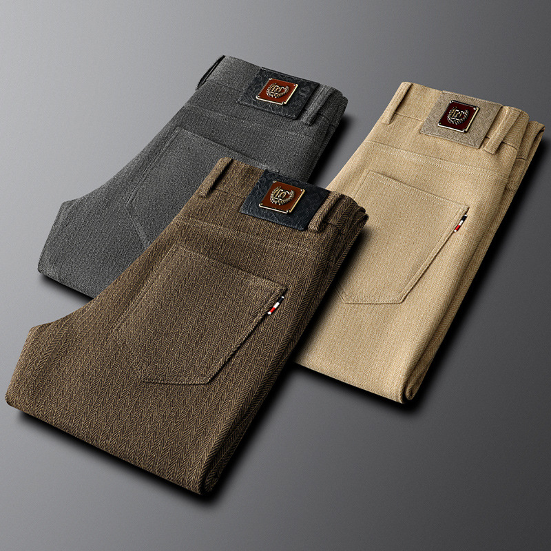 Close-up of khaki herringbone fabric on men's tailored trousers, highlighting the texture and refined detail.