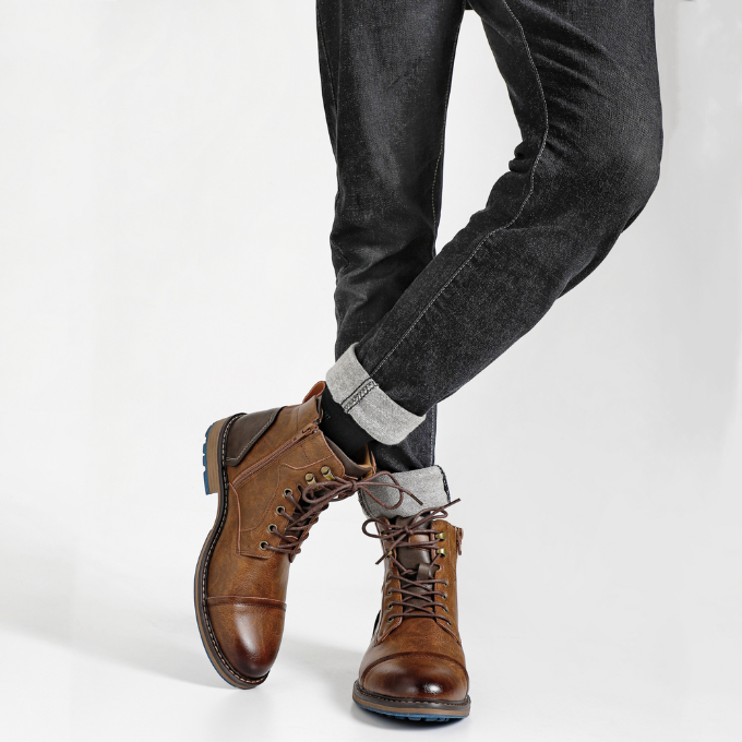 Pair of men's rugged leather boots, ideal for casual wear, standing on a wooden surface.