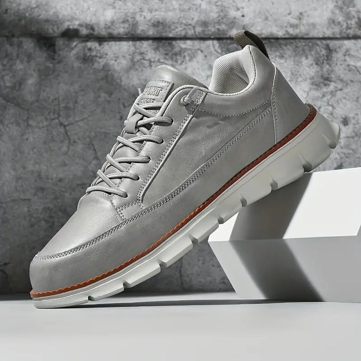 Detailed shot of the stitching on men's premium white leather casual sneakers, quality craft