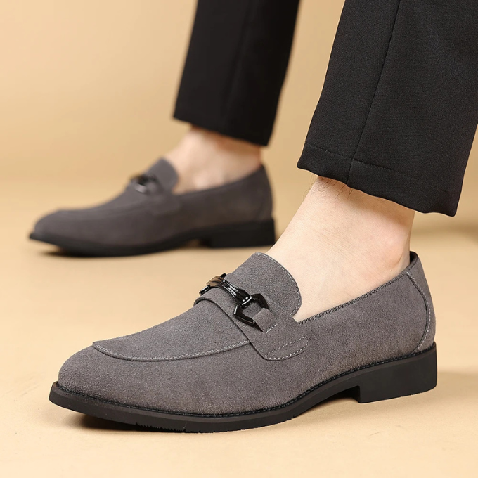 Close-up of men's blue suede slip-on loafers, showcasing velvet texture and modern style.