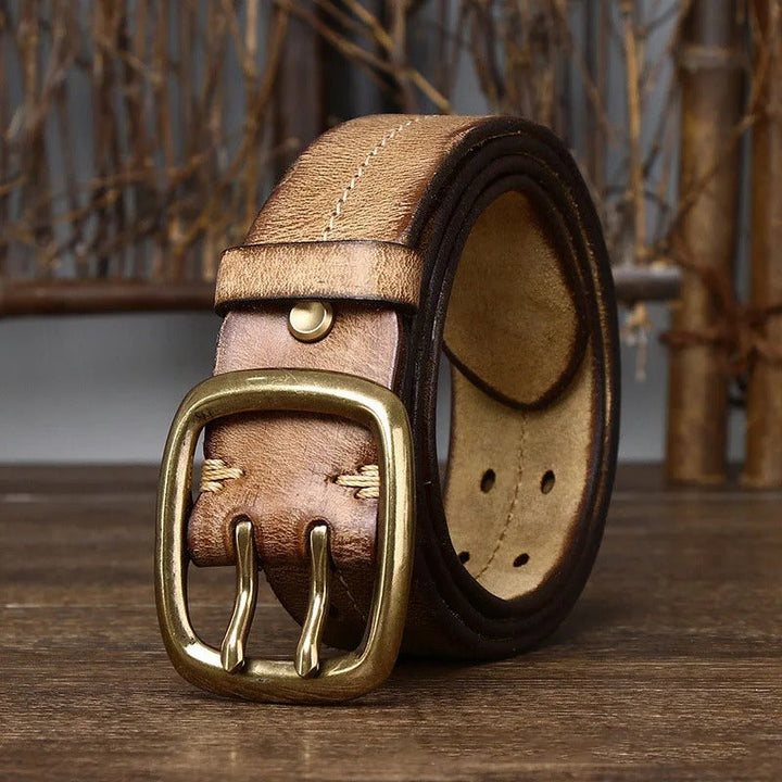 A stack of durable men's cowhide leather belts in various colors, all with brass buckles