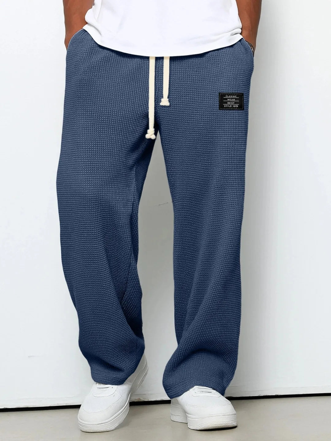 Comfortable grey men's casual pants. Relaxed fit waffle knit trousers with adjustable drawstring waist for lounging.