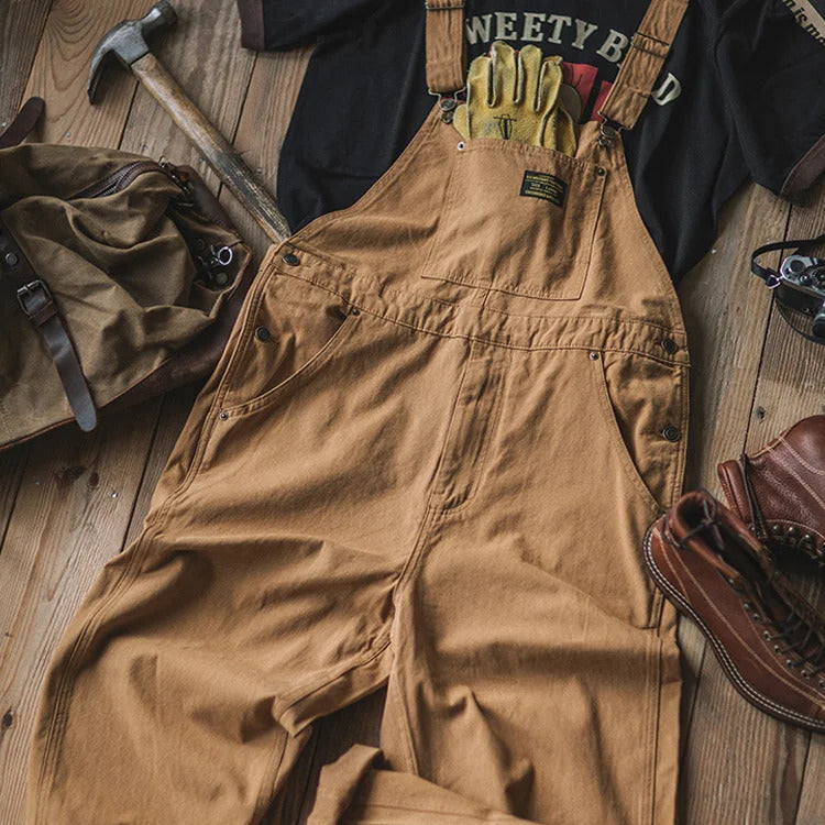 Khaki men's relaxed fit overalls, featuring practical bib pockets and comfortable adjustable straps. Great for utility & style.
