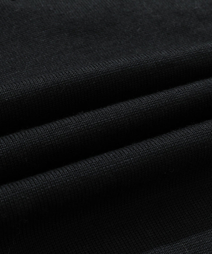 Detail of the half-zip closure on a men's black mock neck sweater, adding modern touch