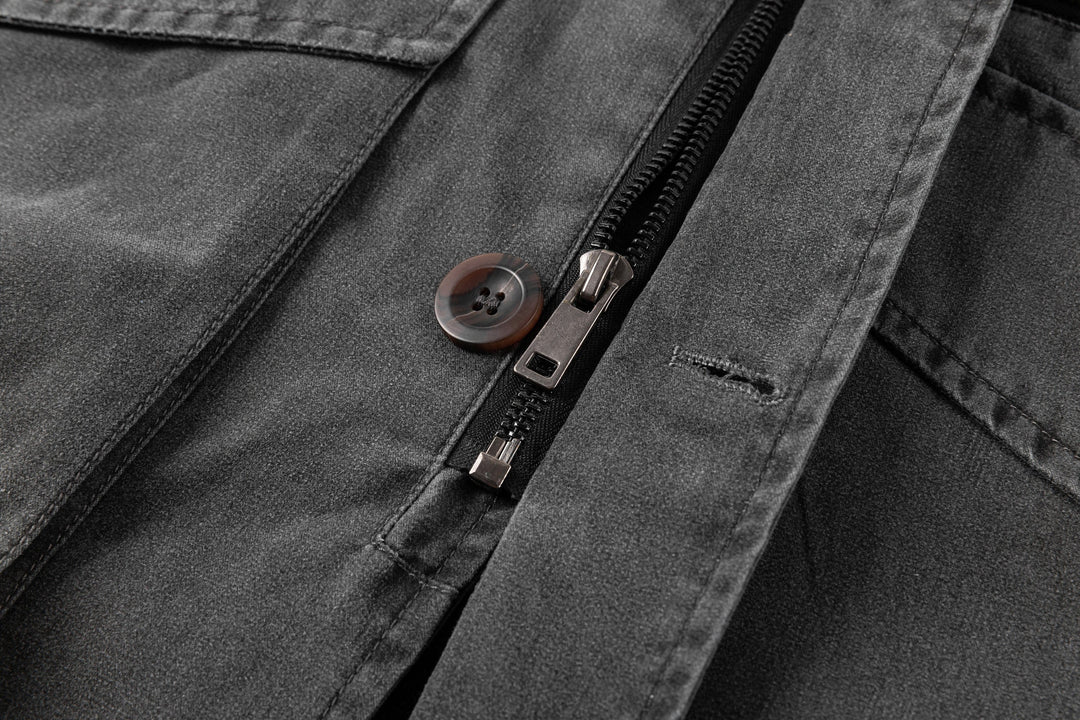A stack of black canvas utility jackets, showing bulk and availability, with corduroy collars visible.