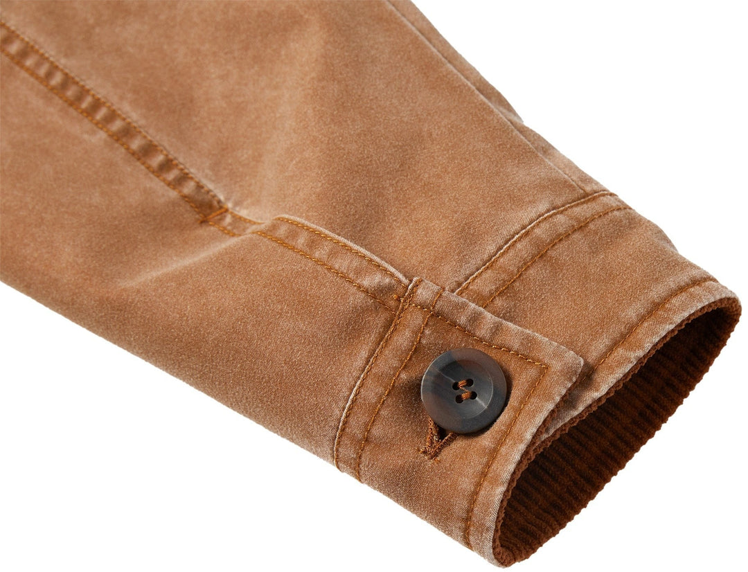 Close-up of the brand logo or tag on a black canvas utility jacket, emphasizing authenticity.
