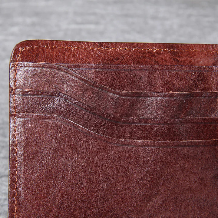 Close-up of the textured genuine cowhide leather on a men's slim bifold wallet.
