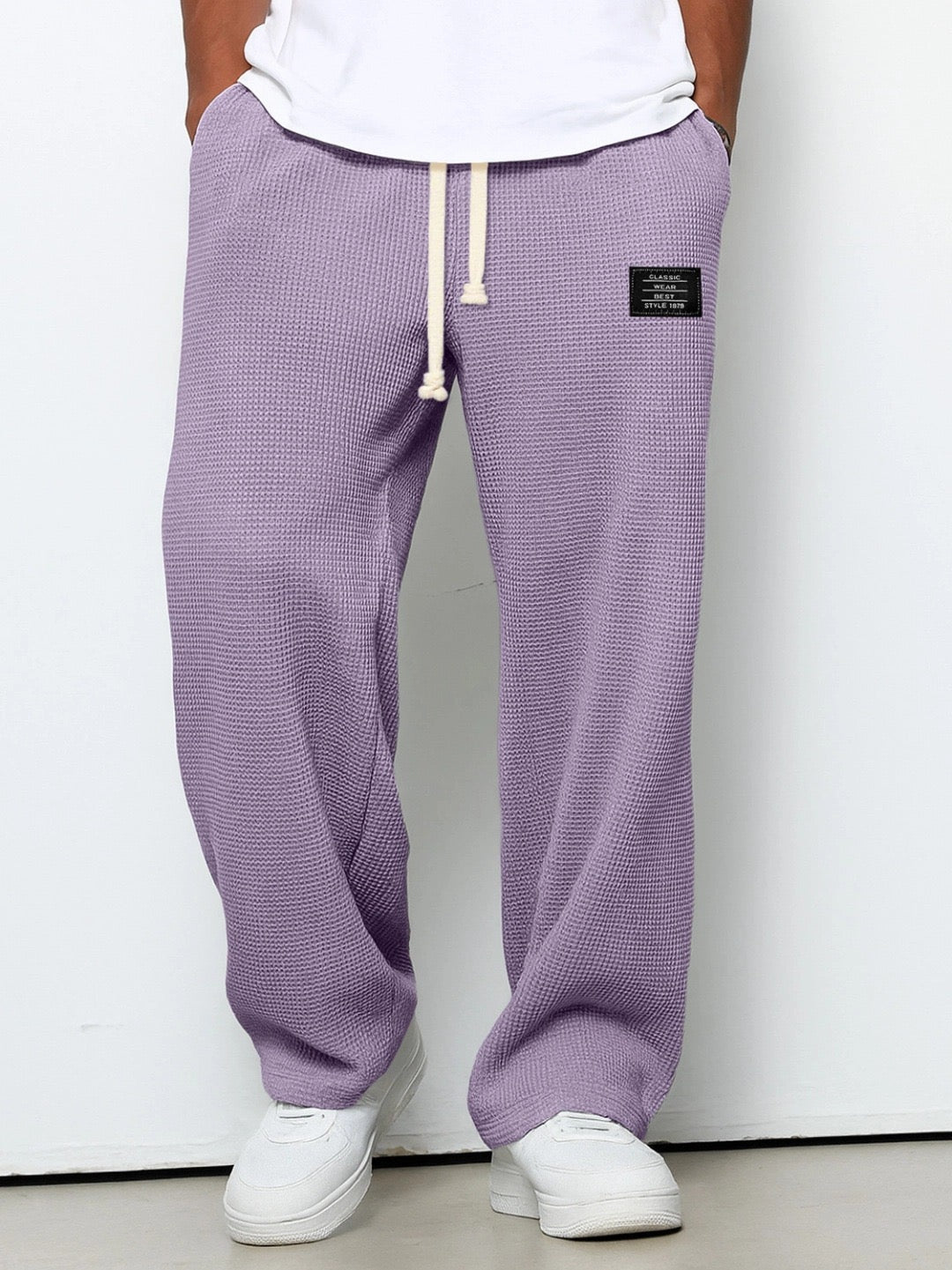 Man wearing Stuart wide leg chino pants while seated, highlighting comfort & relaxed fit for casual style.