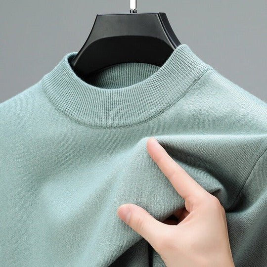 Stylish man in a modern navy mock neck sweater, a versatile long sleeve pullover for men's fashion.