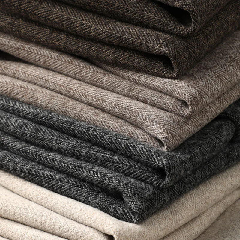 Stack of men's tailored dress trousers in khaki, champagne, brown, and dark grey.