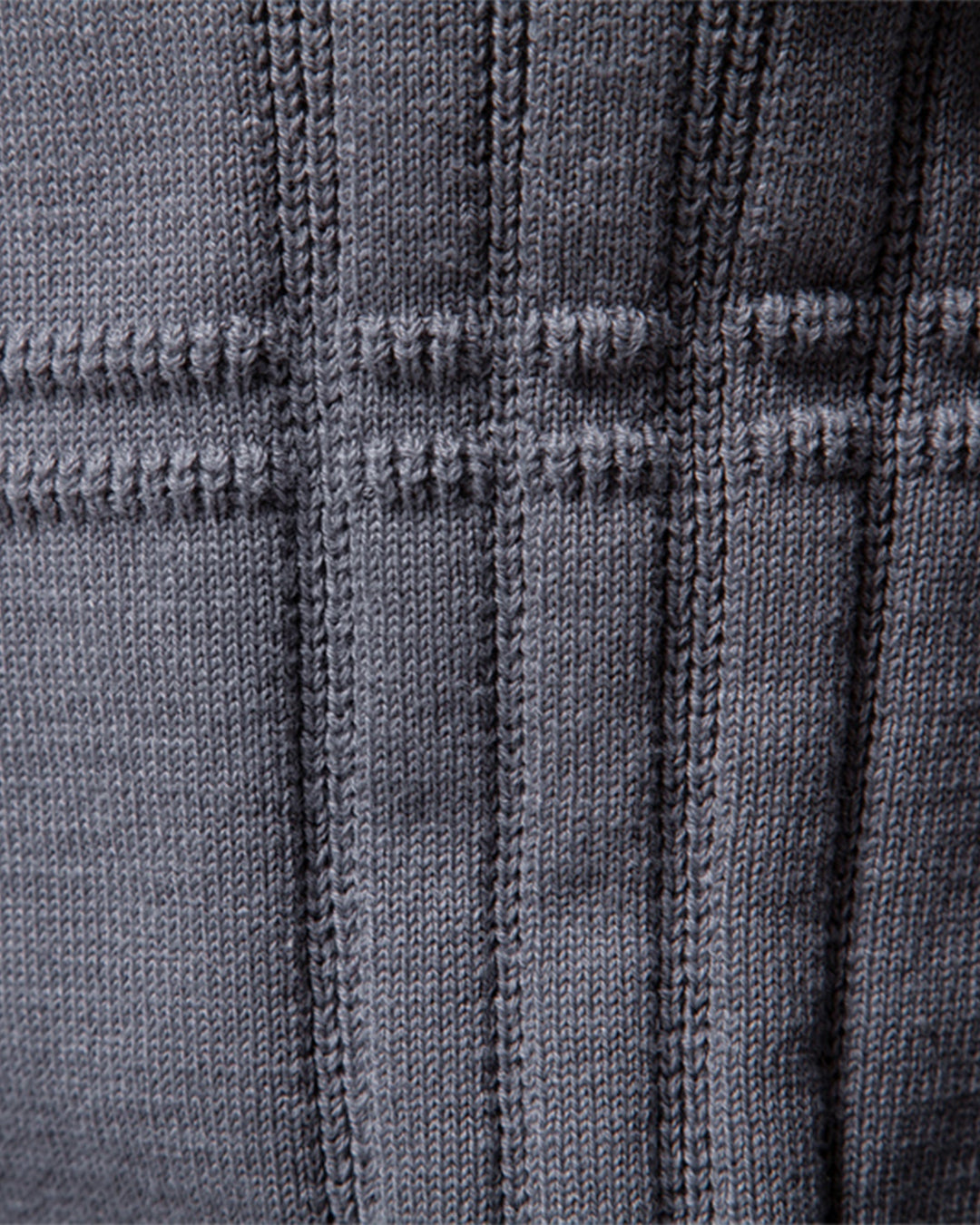 Man's arm in a textured crew neck sweater, highlighting the quality knit