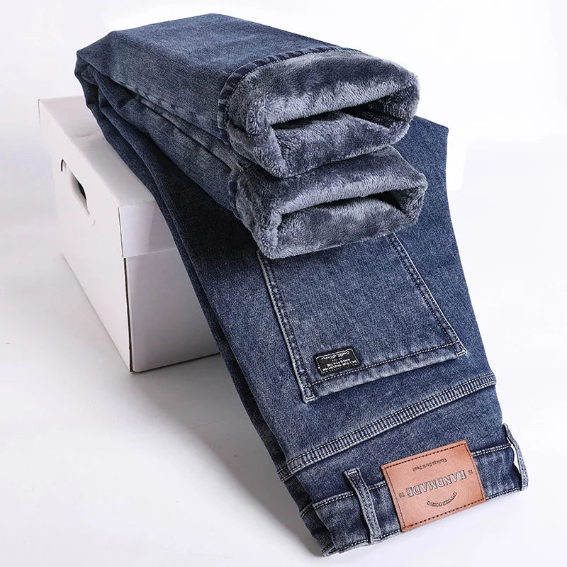 Detail of the waistband and button on men's thermal slim fit jeans. Comfortable stretch denim.