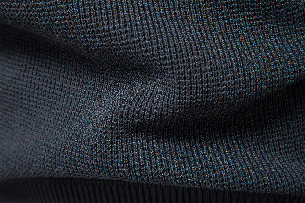 Close-up of the cuff on a men's waffle knit pullover, showcasing fine knitwear detail.