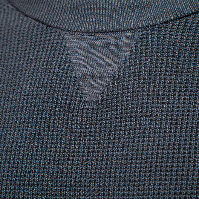 Detail shot of the crew neck collar on a men's waffle knit pullover sweater.