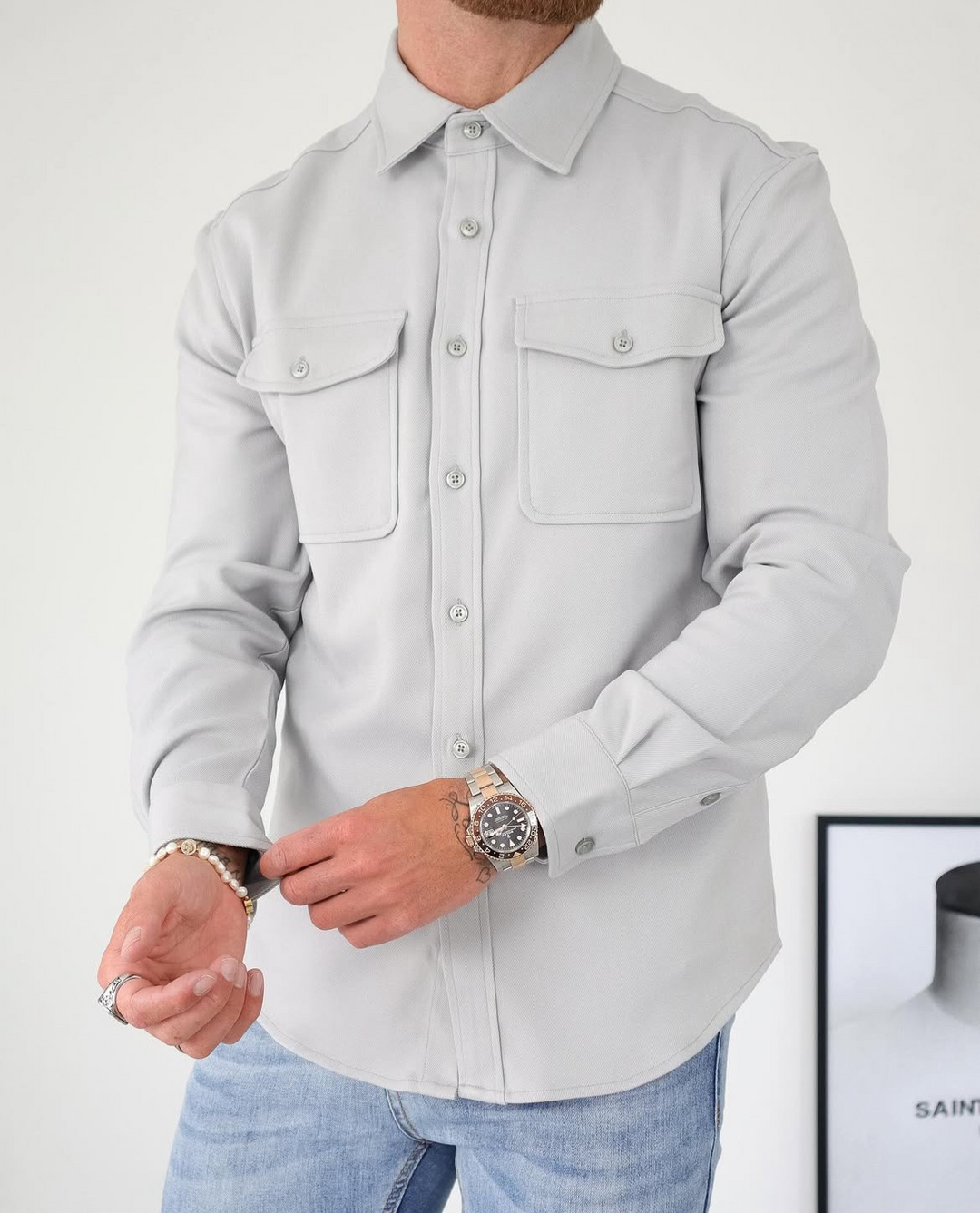 Modern men's fashion: a smart casual button-up overshirt with long sleeves and functional chest pockets.